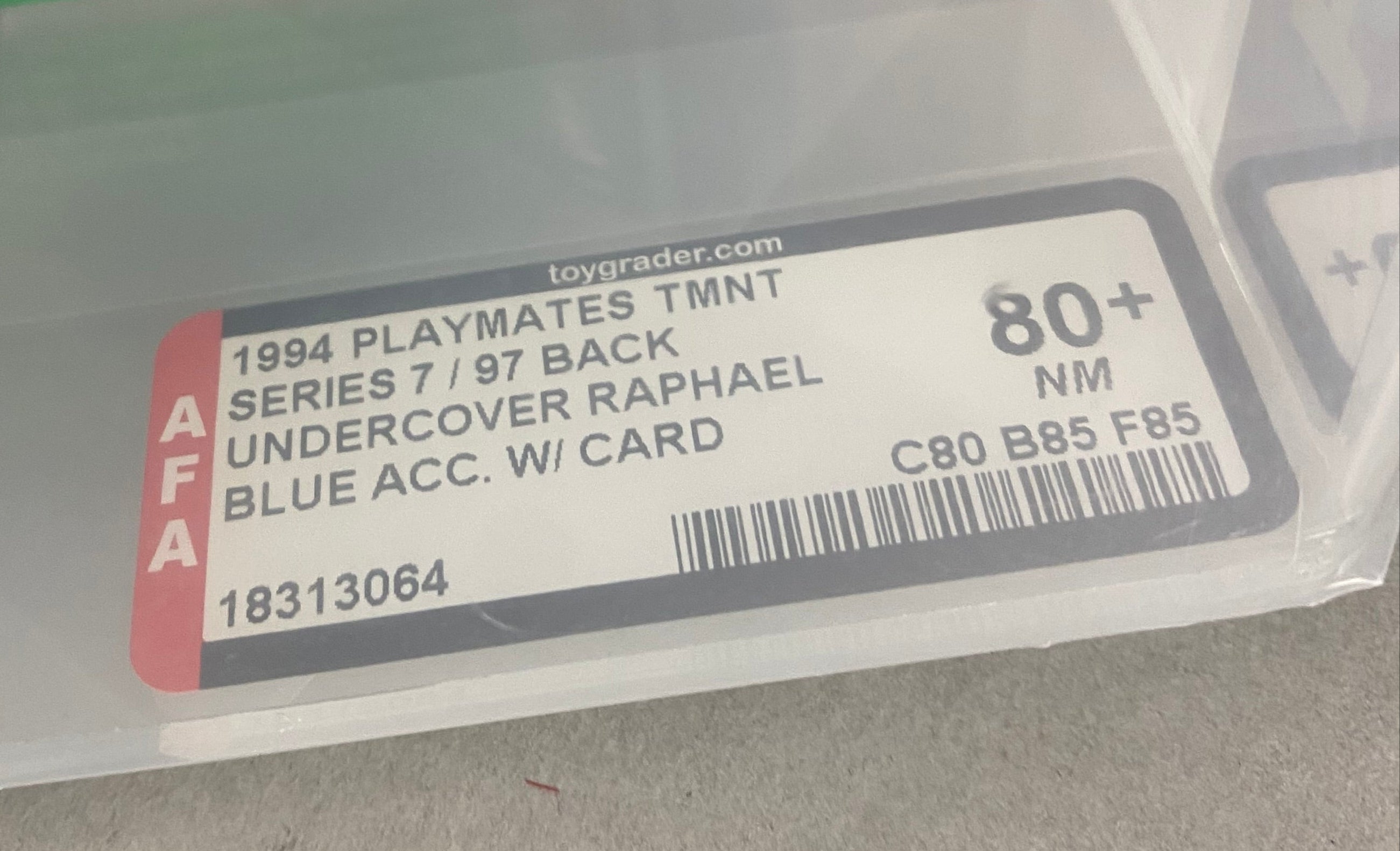 A Teenage Mutant Ninja Figure featuring Raphael from the Undercover series. The figure is graded AFA 80+. Closeup of grading label.